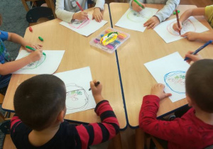 Dzieci samodzielnie rysują wzór (koszyk) kredkami na karcie pracy tak, aby znajdujące się tam warzywa i owoce nalazły się w środku koszyka.